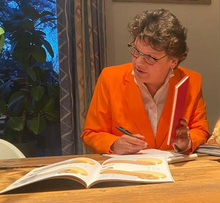 Brenda Molenaar aan tafel met een uitvaartbrochure